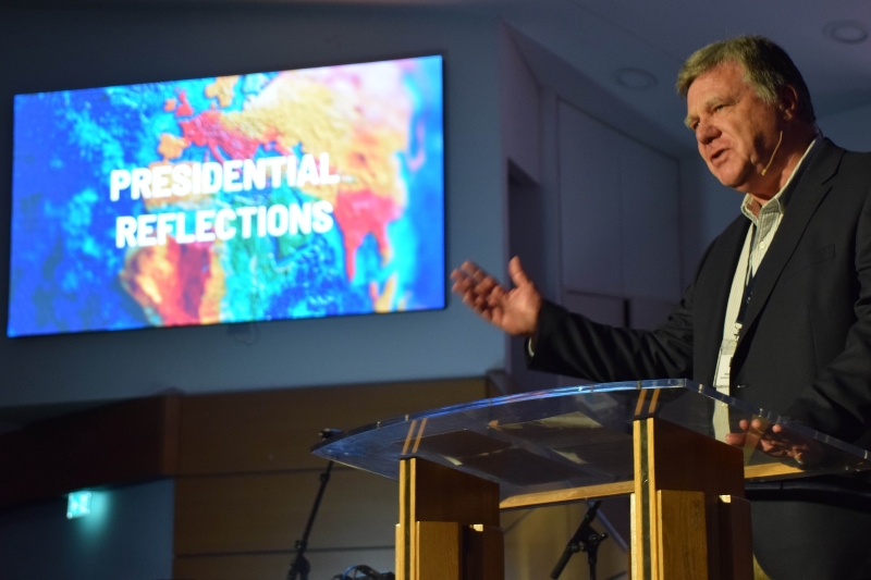 Steve Finamore speaking on stage at the Baptist Assembly in front of a sign saying "Presidential reflections"