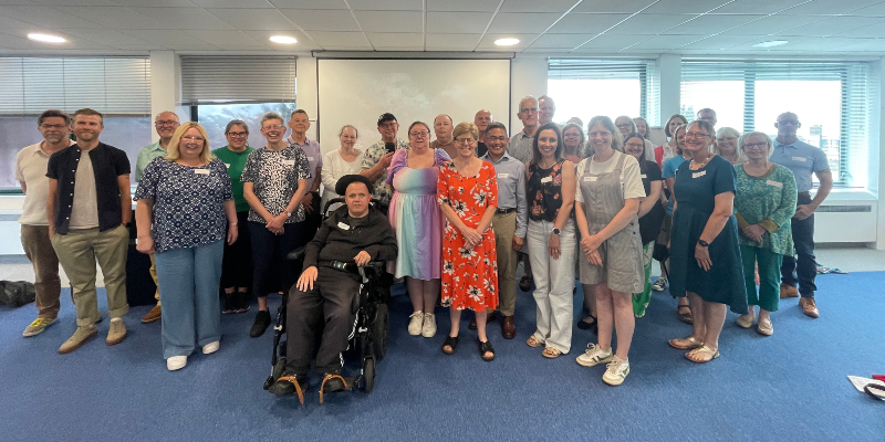 The1st cohort of The Learning Collective stand alongside each other as they pose for a photo in Baptist House - around 30 women and men