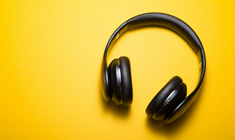 A pair of headphones against a yellow background