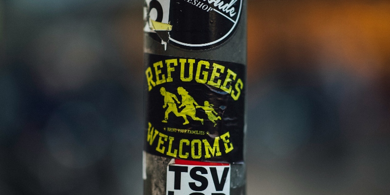 Sticker on a lampost stating "Refugees Welcome"
