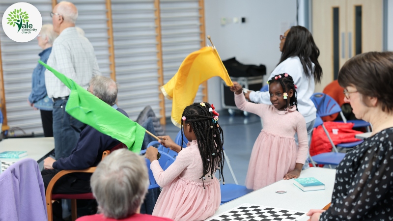 During worship at Vale Community Church two young girls wave flags