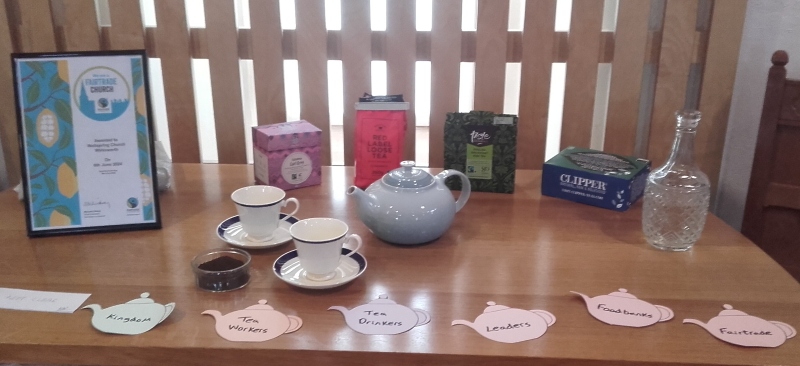 Wirksworth communion table featuring a tea pot and 4 types of tea, 2 cups and saucers and 6 teapot shaped labels