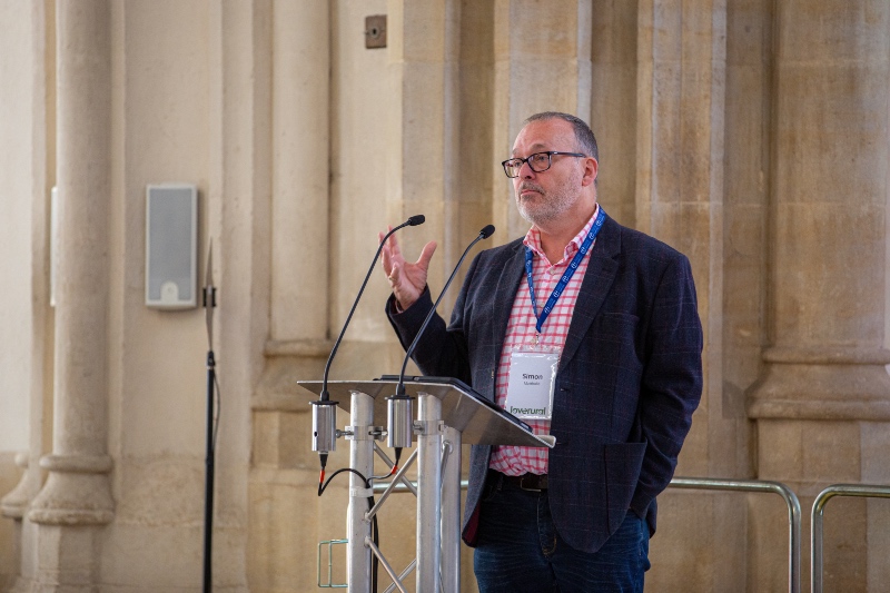 Simon Mattholie speaking at a podium