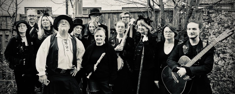 The 13 members of the Hedge Band, in costume and with some holding instruments