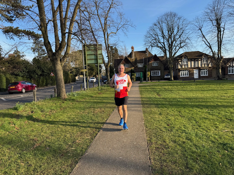 Philip Amos running in a park where a Christian Aid top